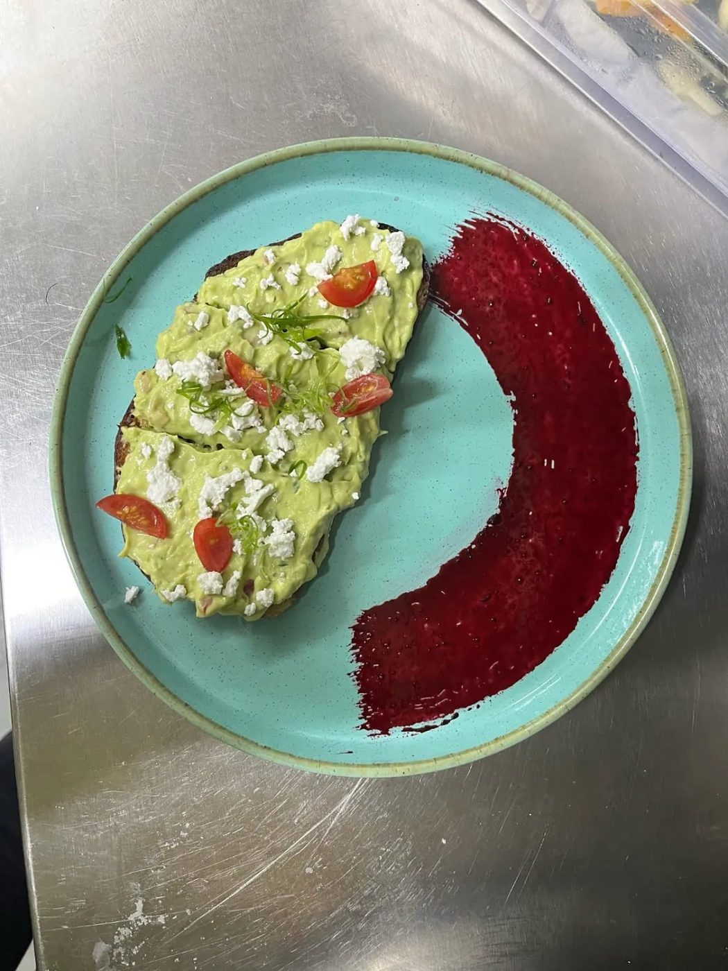 Avocado toast with feta and cherry tomato beside a beetroot swirl