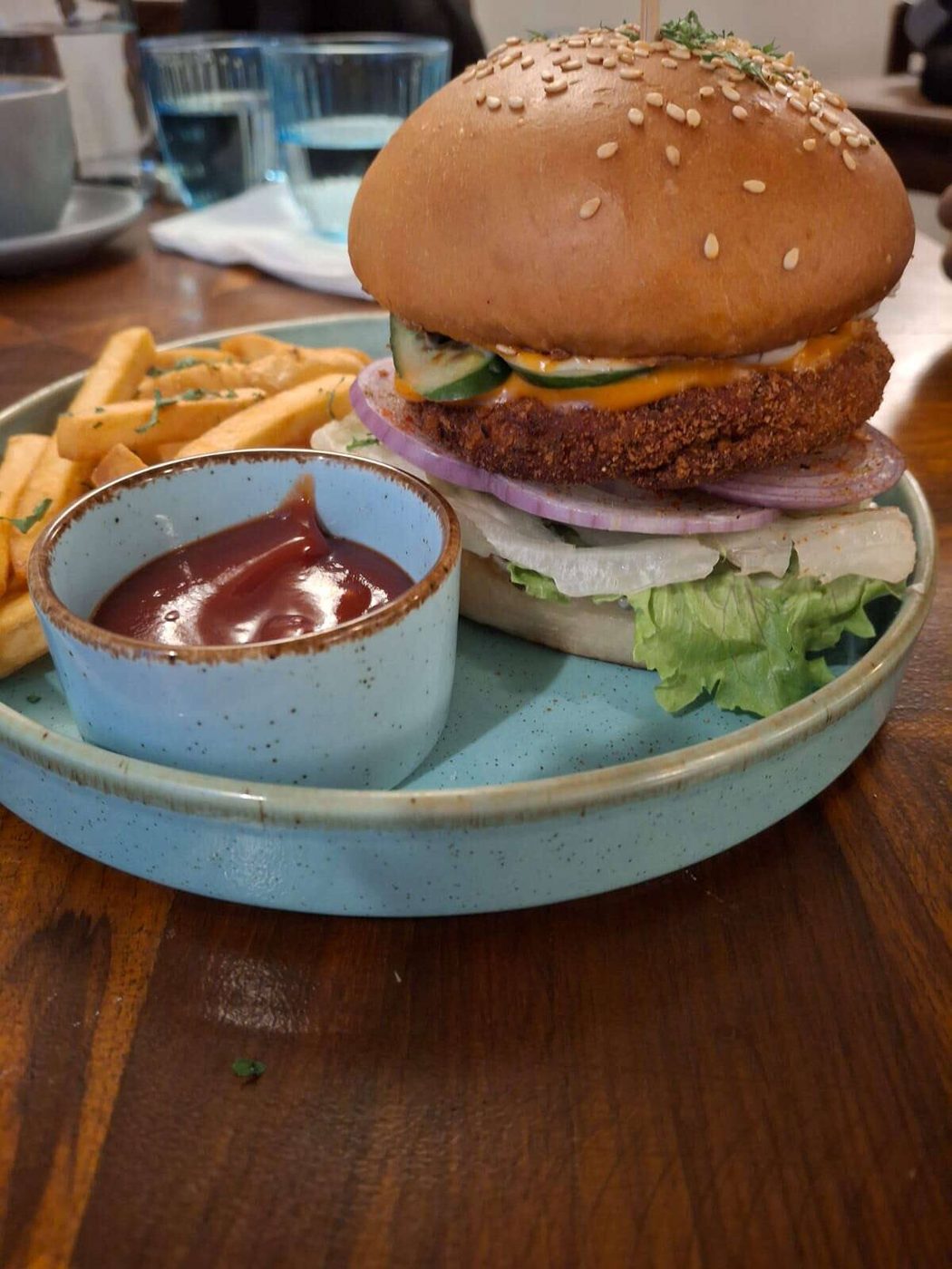 A tall corn veg burger with fries and ketchup