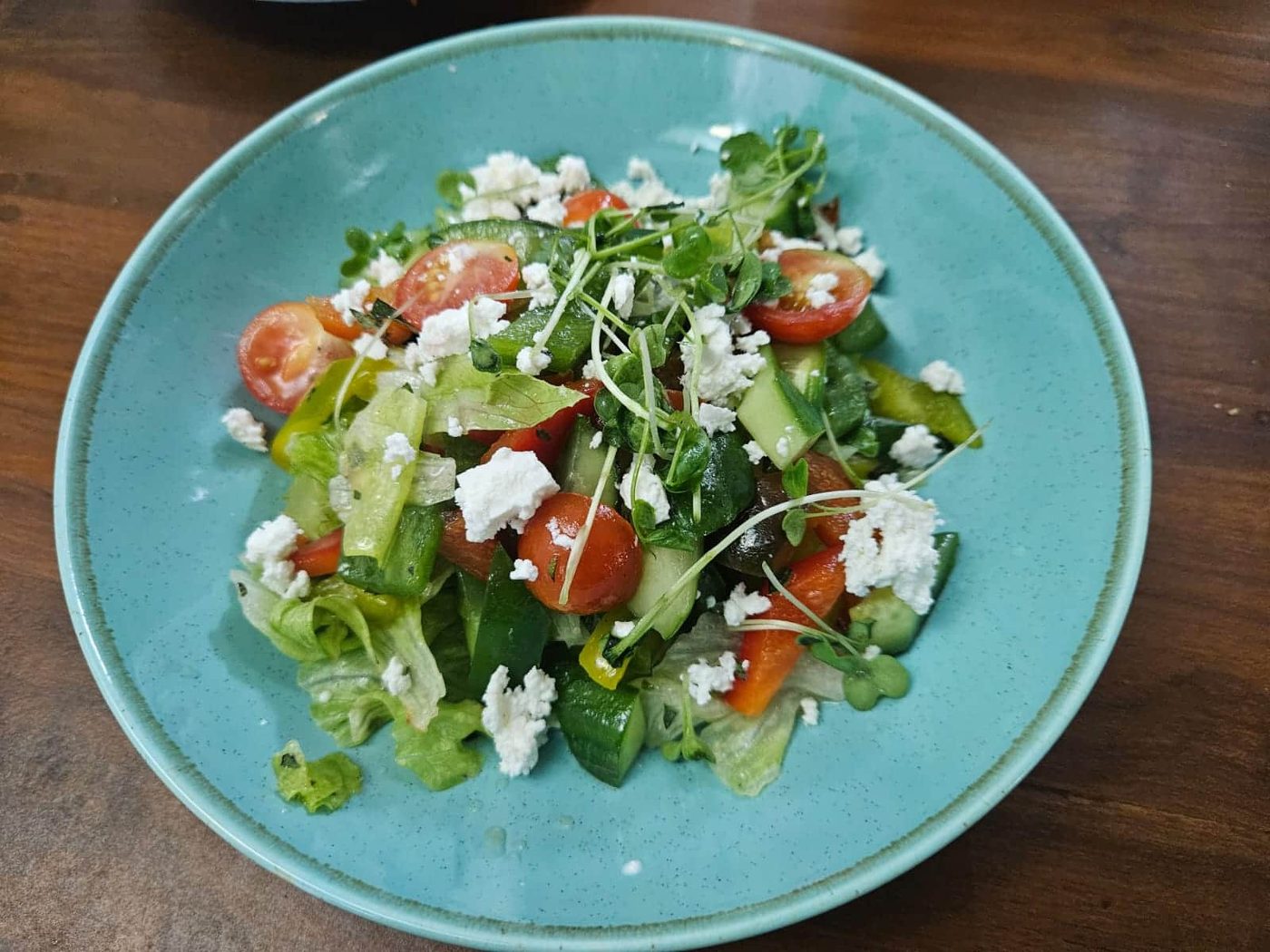 A garden salad with cherry tomato, cucumber and crumbled feta