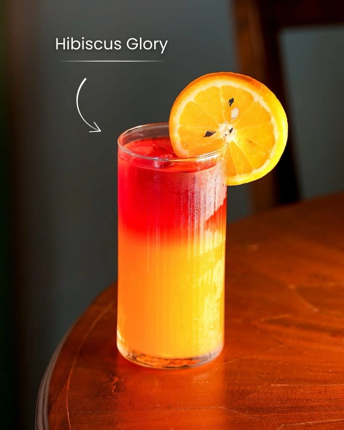 A layered red and orange cooler with an orange wheel on the rim