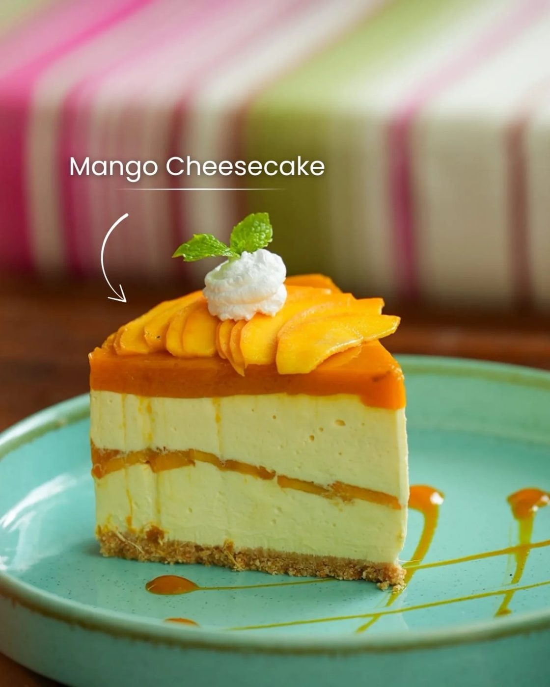 A slice of mango cheesecake with a mango glaze on a green plate