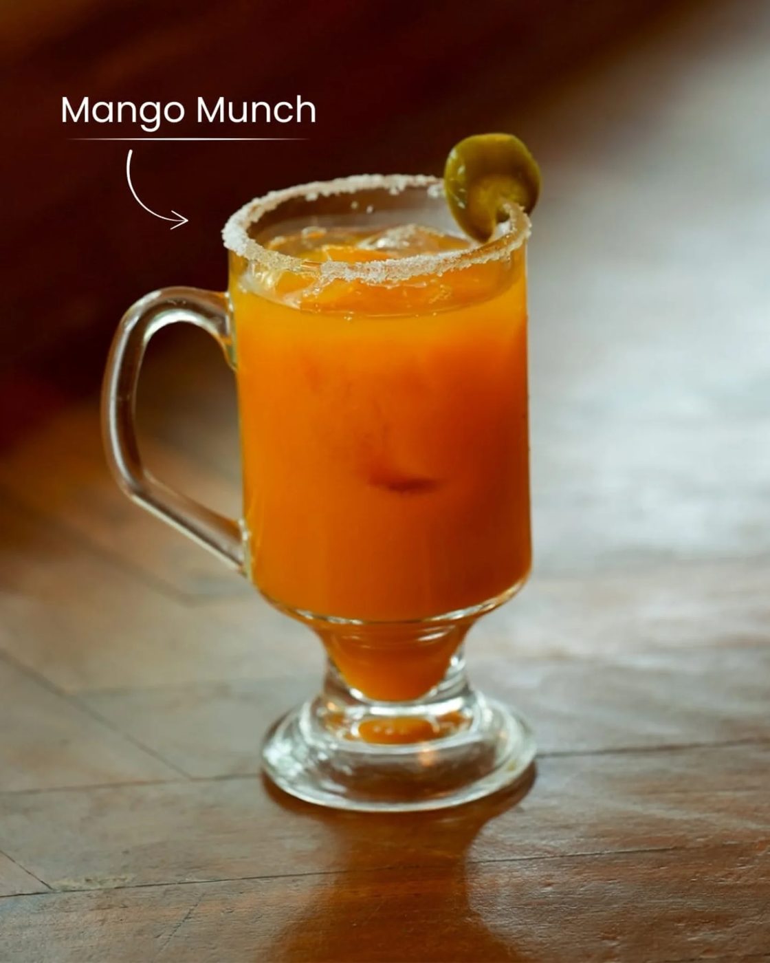 A chilled mango cooler in a glass mug with a salted rim