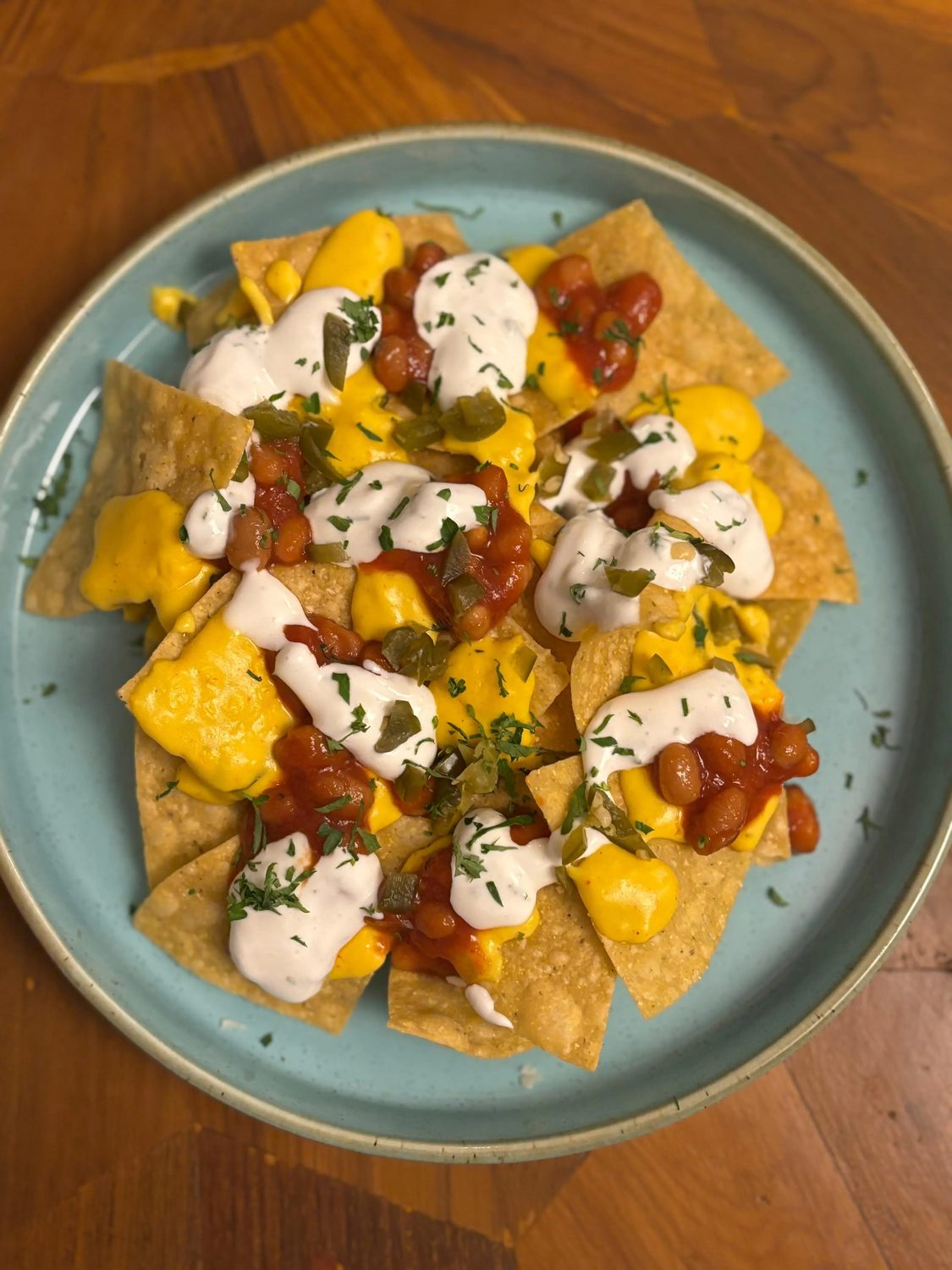 Nachos with mango salsa, cheese sauce and sour cream