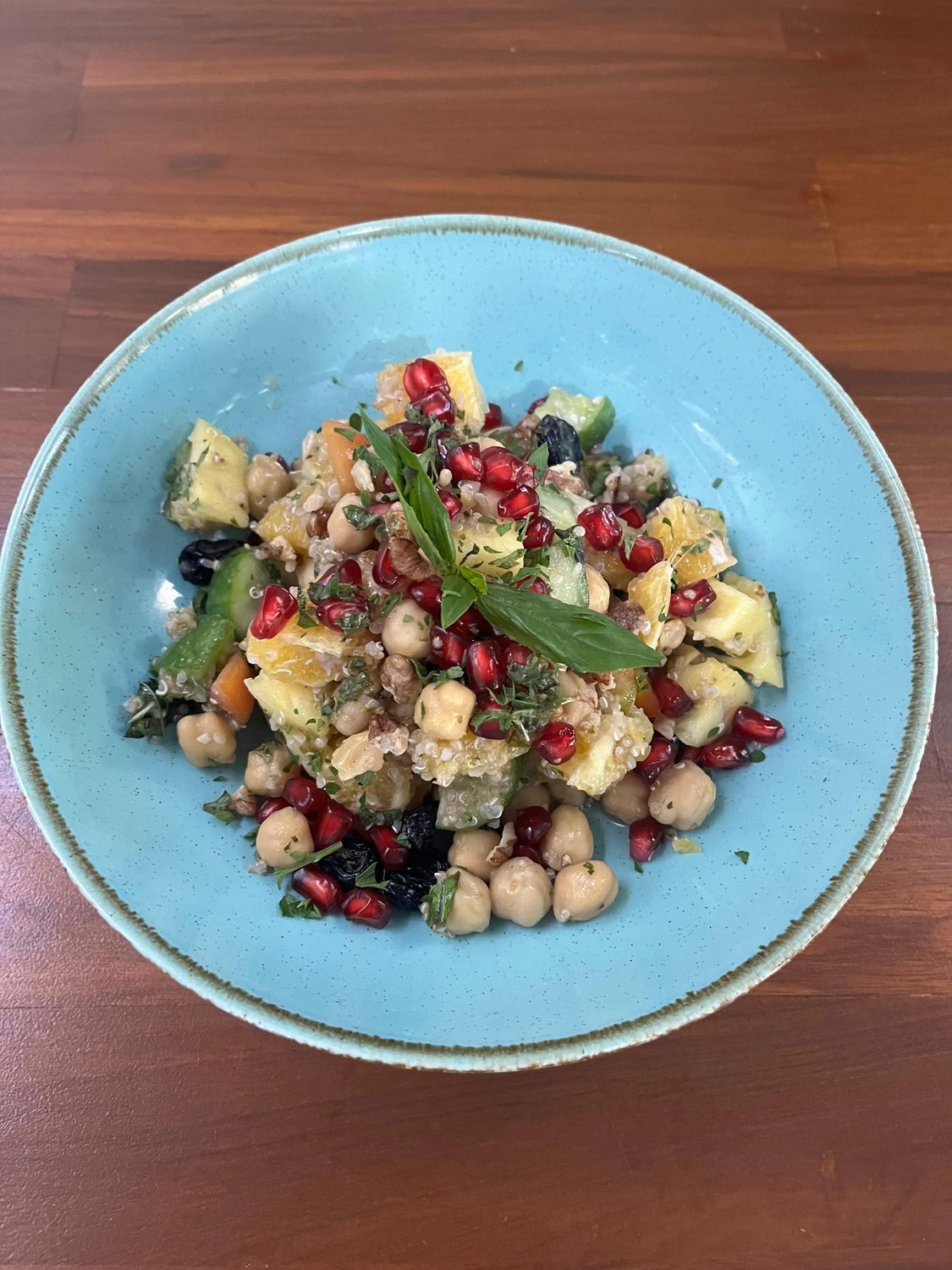A quinoa bowl with chickpea, pomegranate and basil