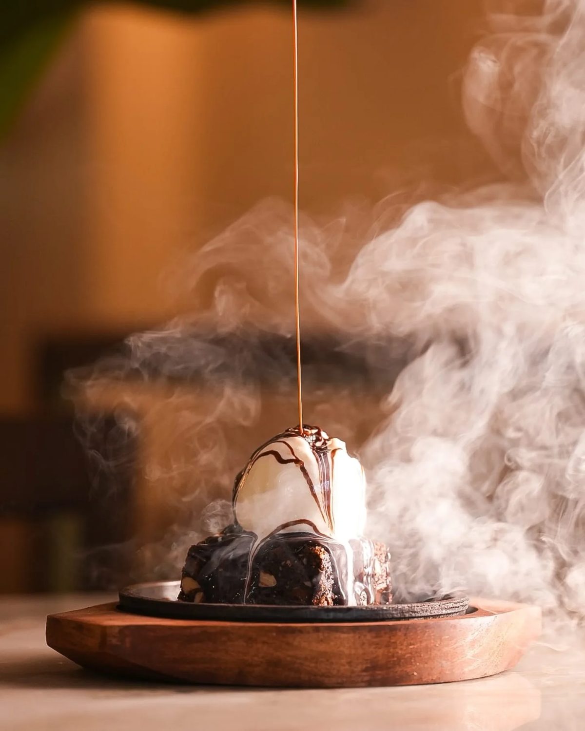 Chocolate walnut brownie on a hot sizzler platter under a cloud of steam