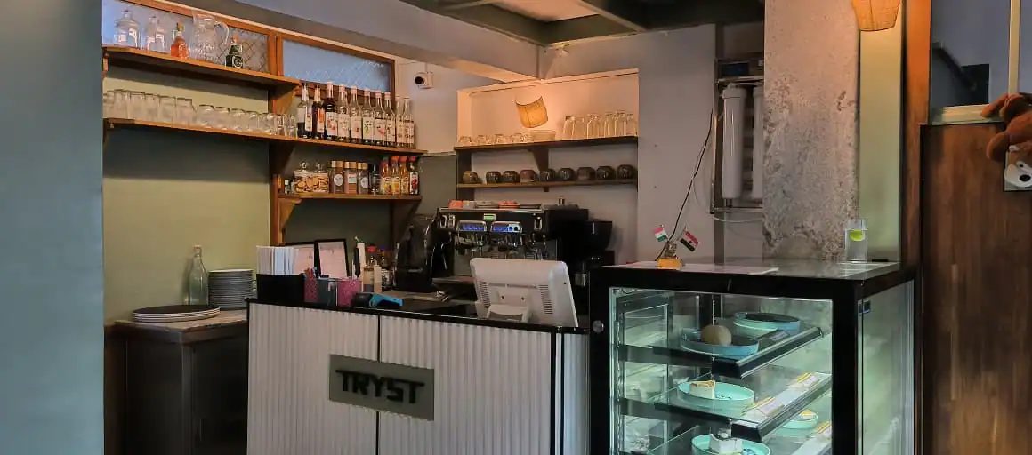 The service counter with the pastry case and coffee machine