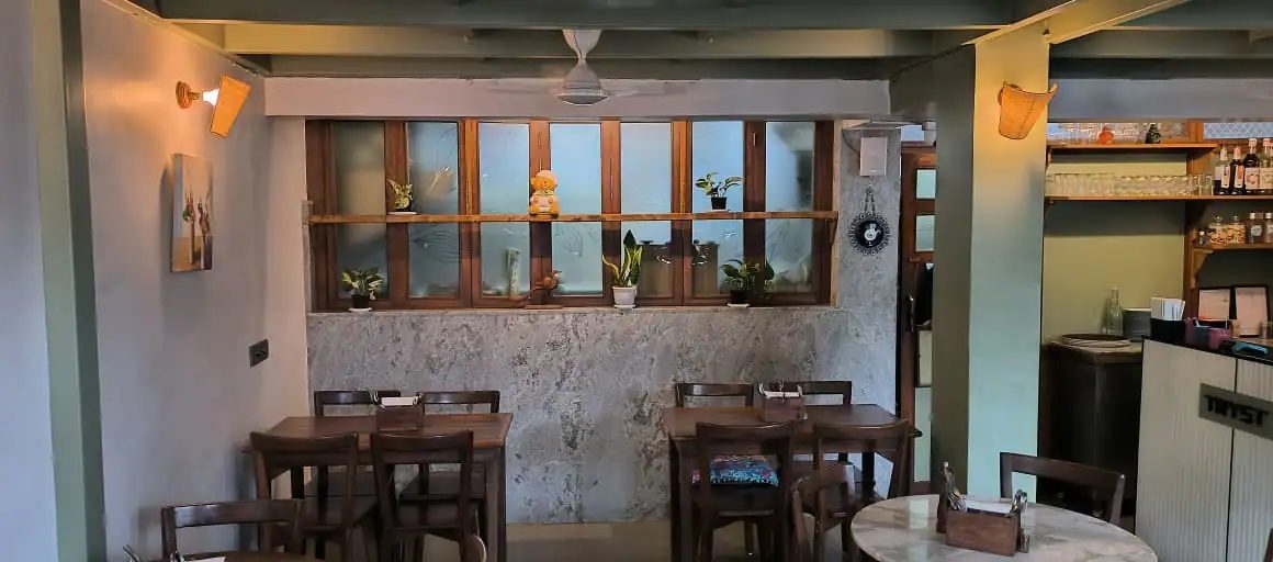 A quiet corner of the café with tables under a wall lamp