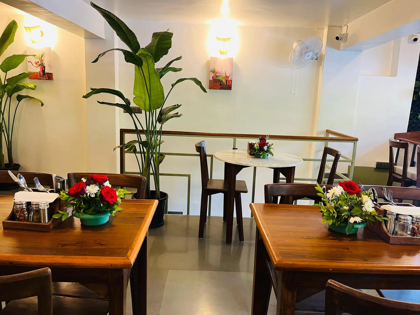 Tables set with small vases of fresh flowers under warm lights